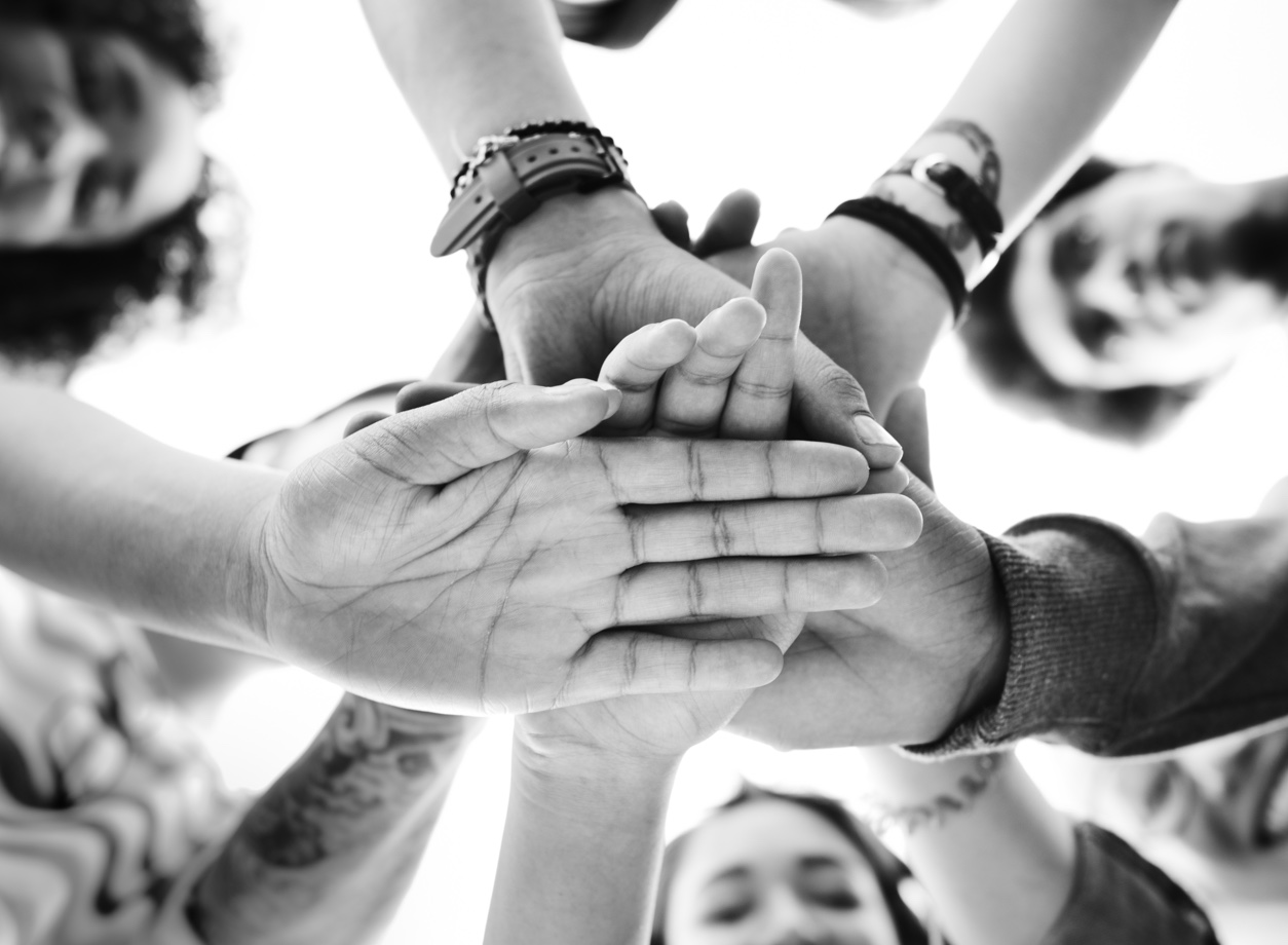 A group of students joining their hands together in collaboration